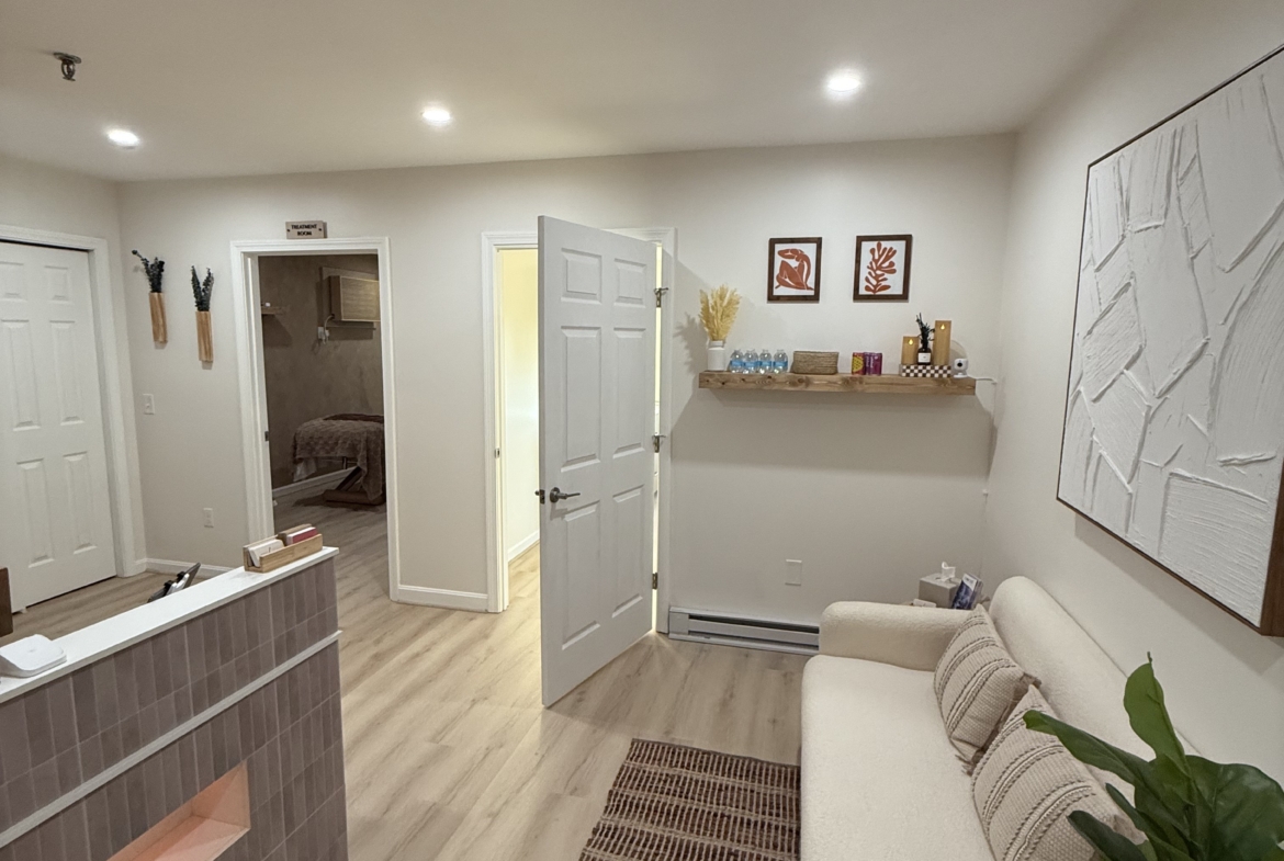 Bright salon rental space with cozy seating and modern decor.