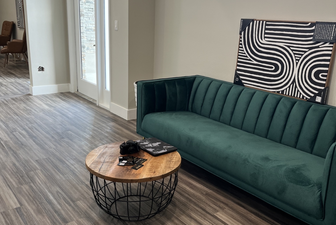 Comfortable salon waiting area with stylish green sofa and modern decor.