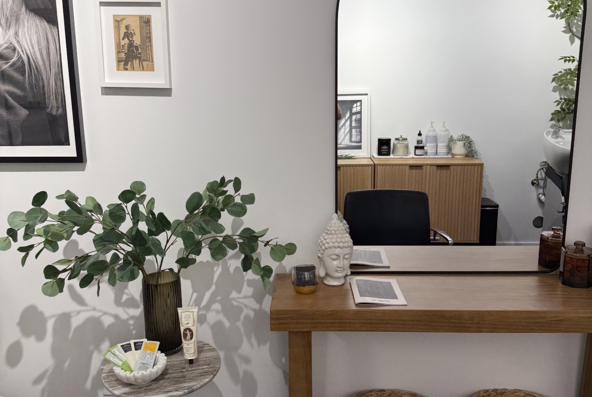 Stylish salon interior featuring a large mirror, seating area, and decorative plants for a welcoming ambiance.