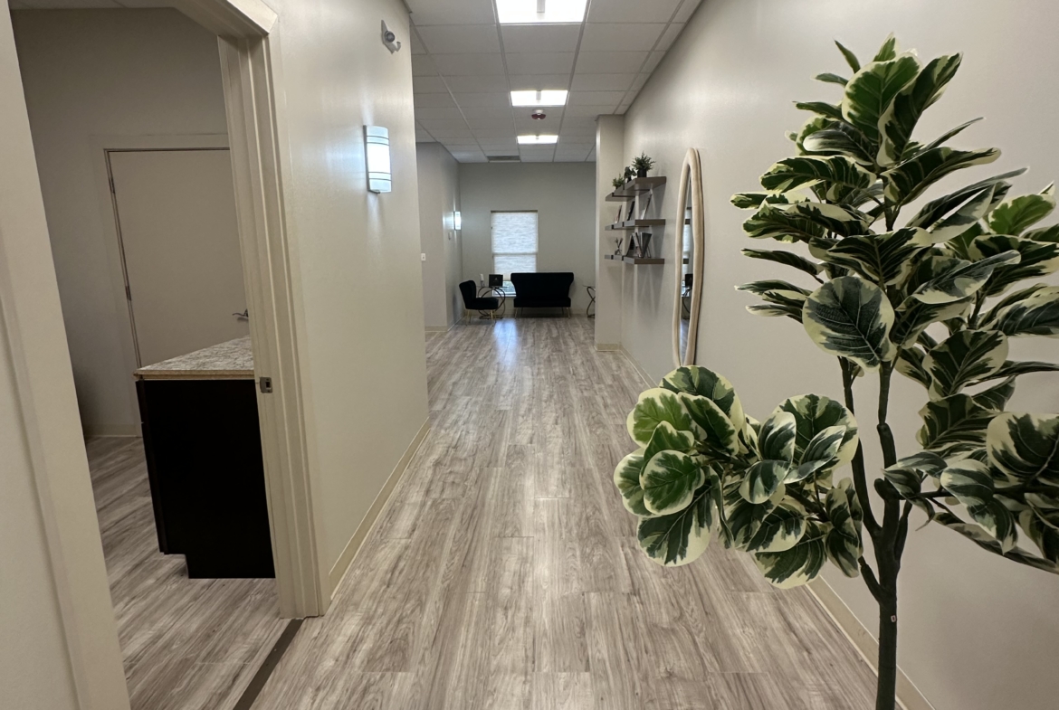 Bright salon hallway with modern decor and natural light, showing a welcoming space for beauty professionals.