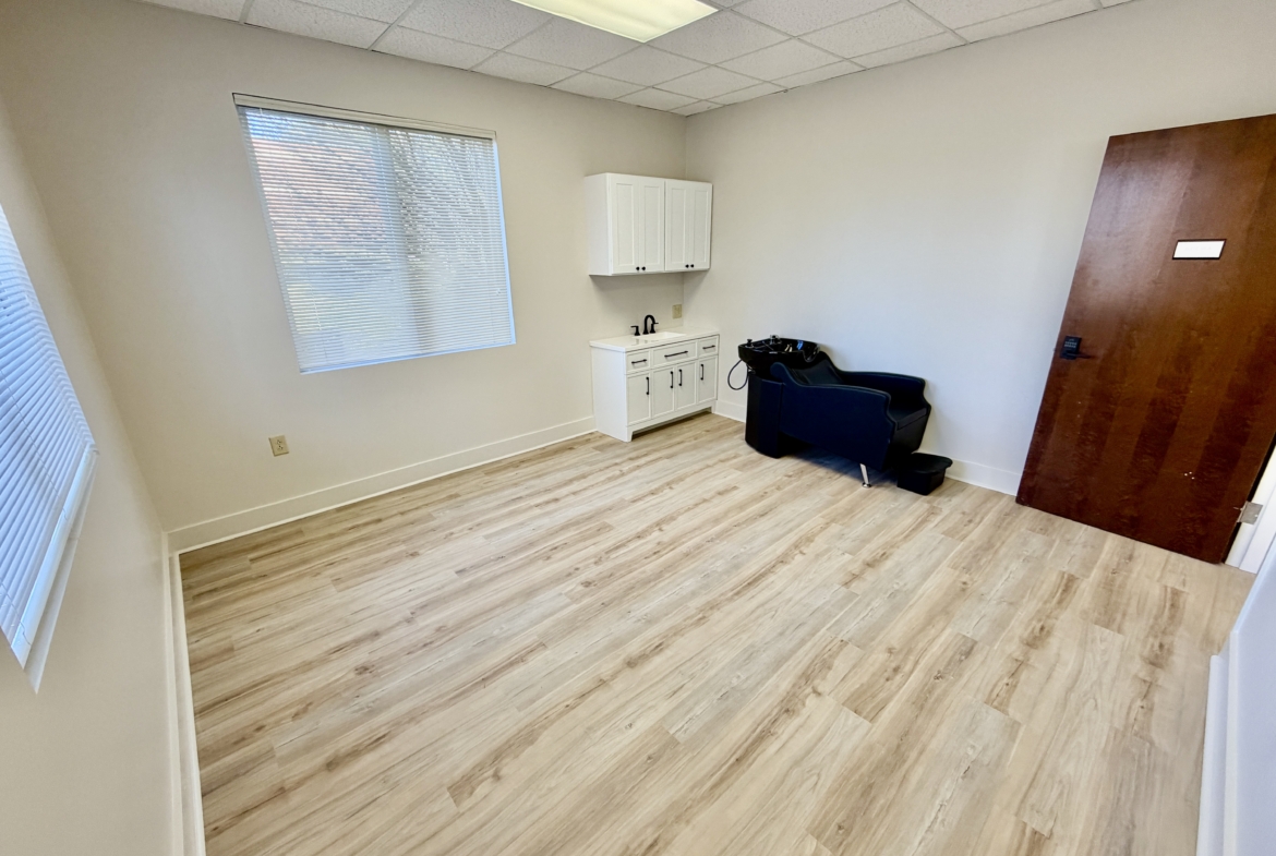 Bright salon rent space featuring natural light, hardwood floors, and essential salon amenities.