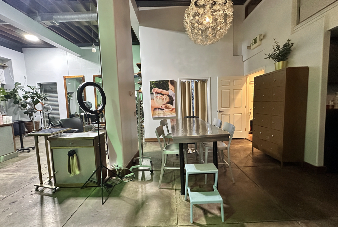 Versatile salon space with seating, mirrors, and massage station for hairstyling and beauty services.