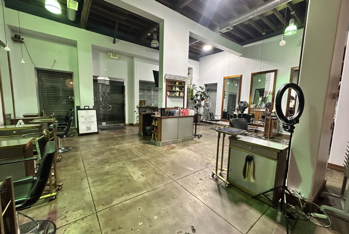 Hair salon interior with styling chairs, mirrors, and professional equipment.