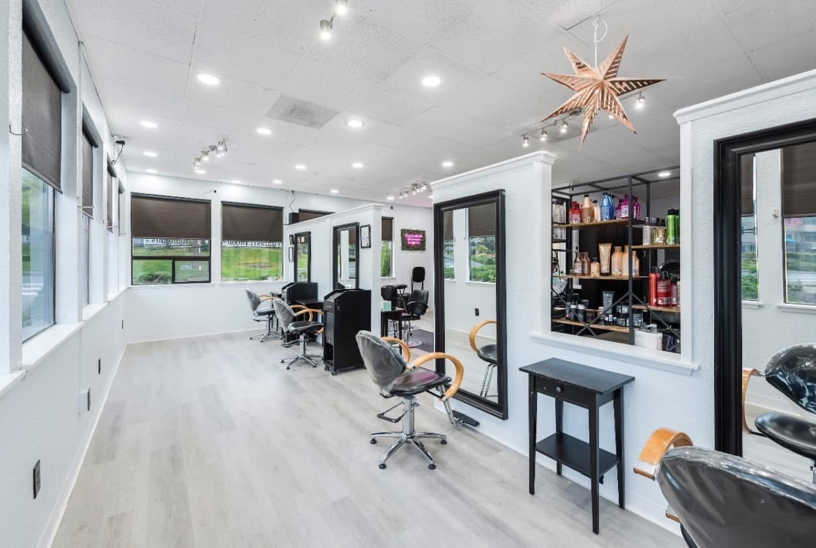 Clean, stylish salon space with styling chairs and hair product shelves.