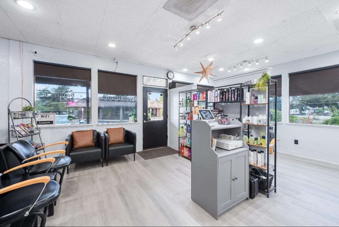 Bright salon waiting area with seating and product shelves.