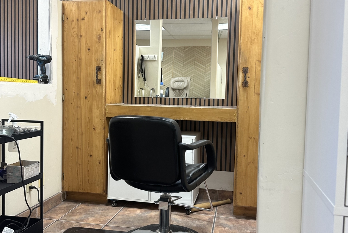 Salon renter styling station with mirror and chair in salon.