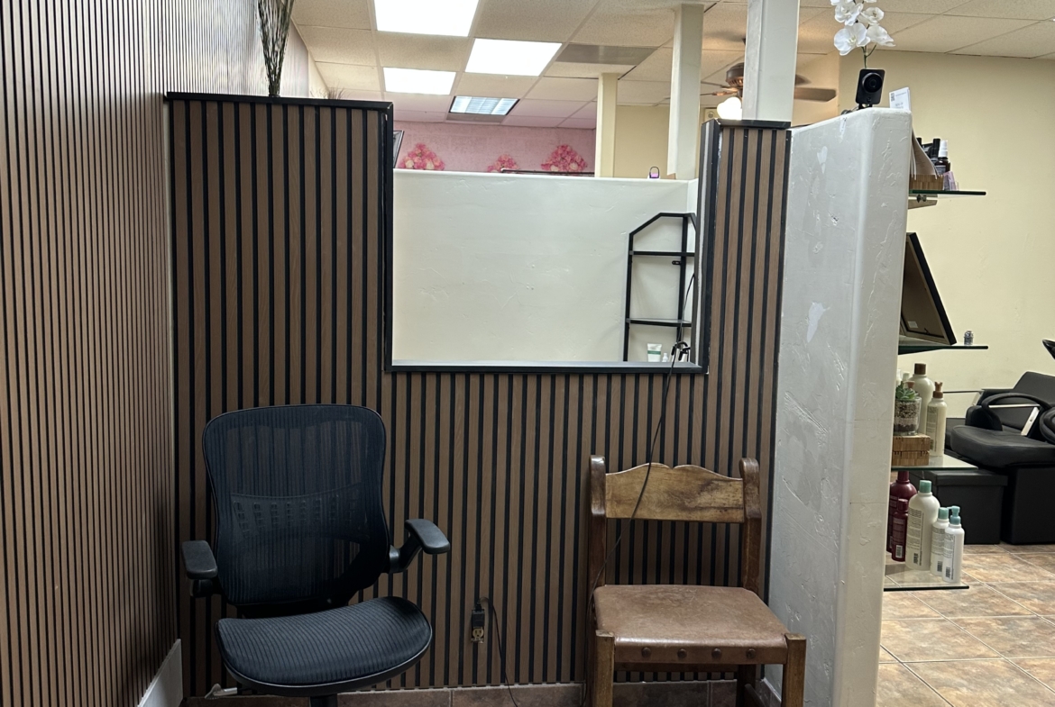 Comfortable black office chair and wooden chair in stylish salon interior.
