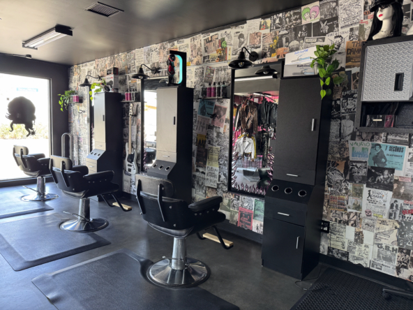 Stylish modern hair salon station with chairs, mirrors, and vibrant wall art in a trendy salon environment.