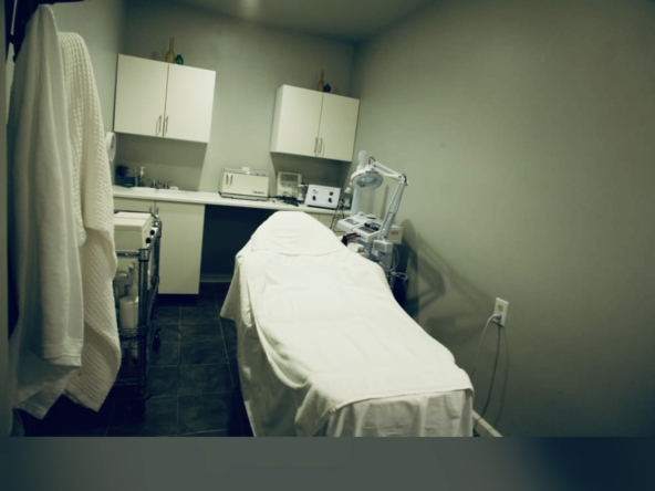 Clean medical treatment room with examination bed and modern equipment.