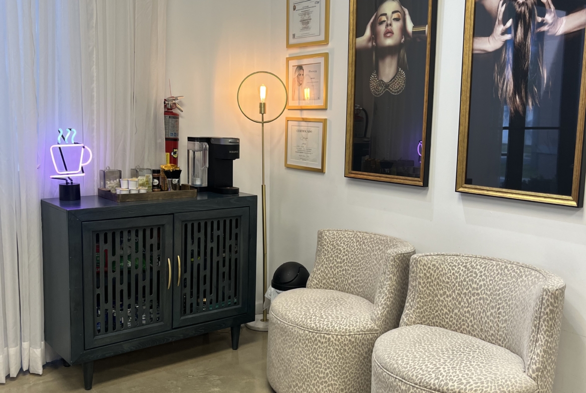 Comfortable salon seating with contemporary decor and framed beauty industry photographs.
