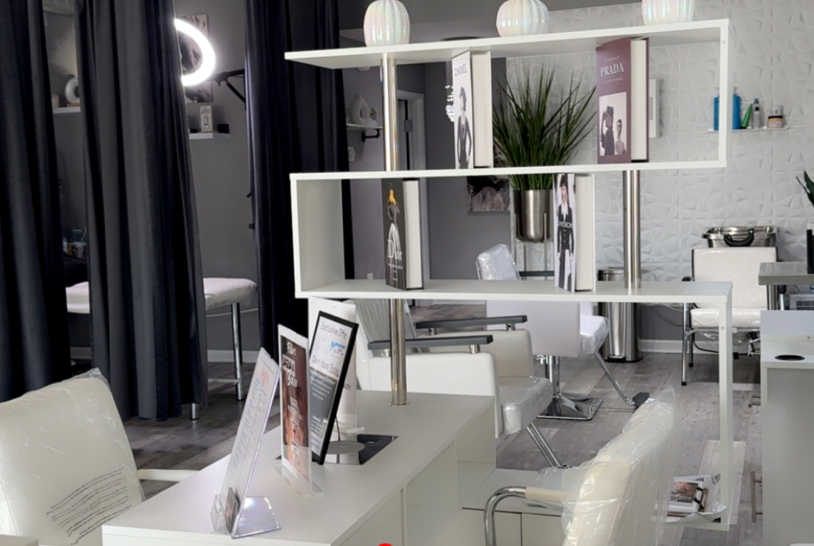 Bright modern salon with stylish workstations, decorative lighting, and contemporary decor.
