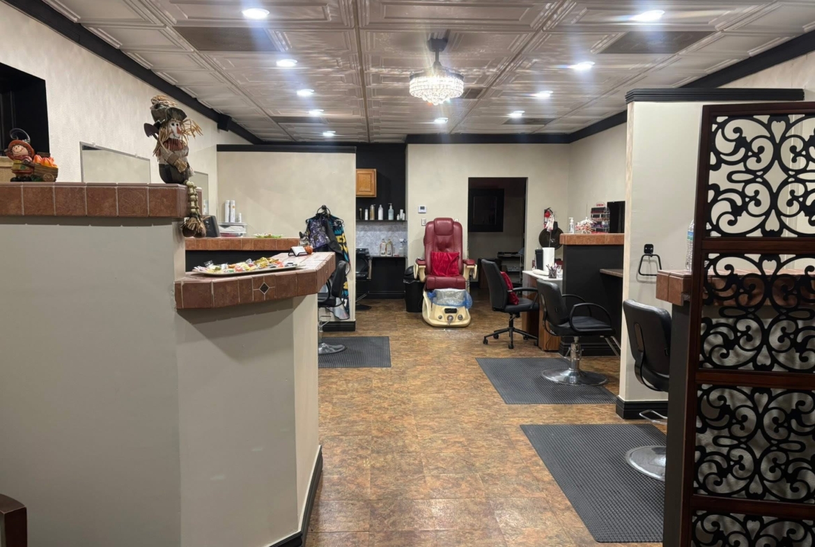Bright hair salon with multiple styling stations, comfortable chairs, and a relaxing massage chair for clients.
