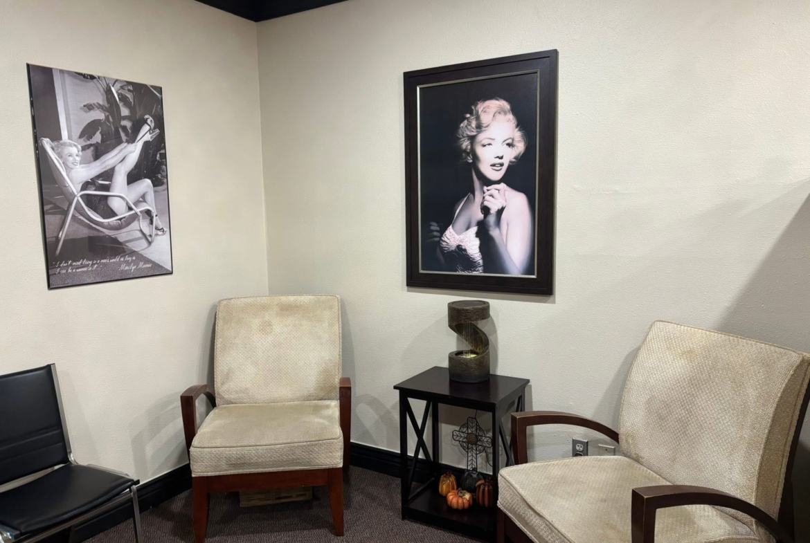 Stylish salon waiting area with vintage photos, comfortable chairs, and modern decor.