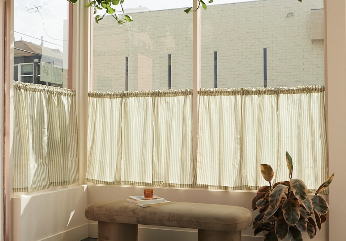 Bright salon space with tranquil seating, indoor greenery, and natural light.