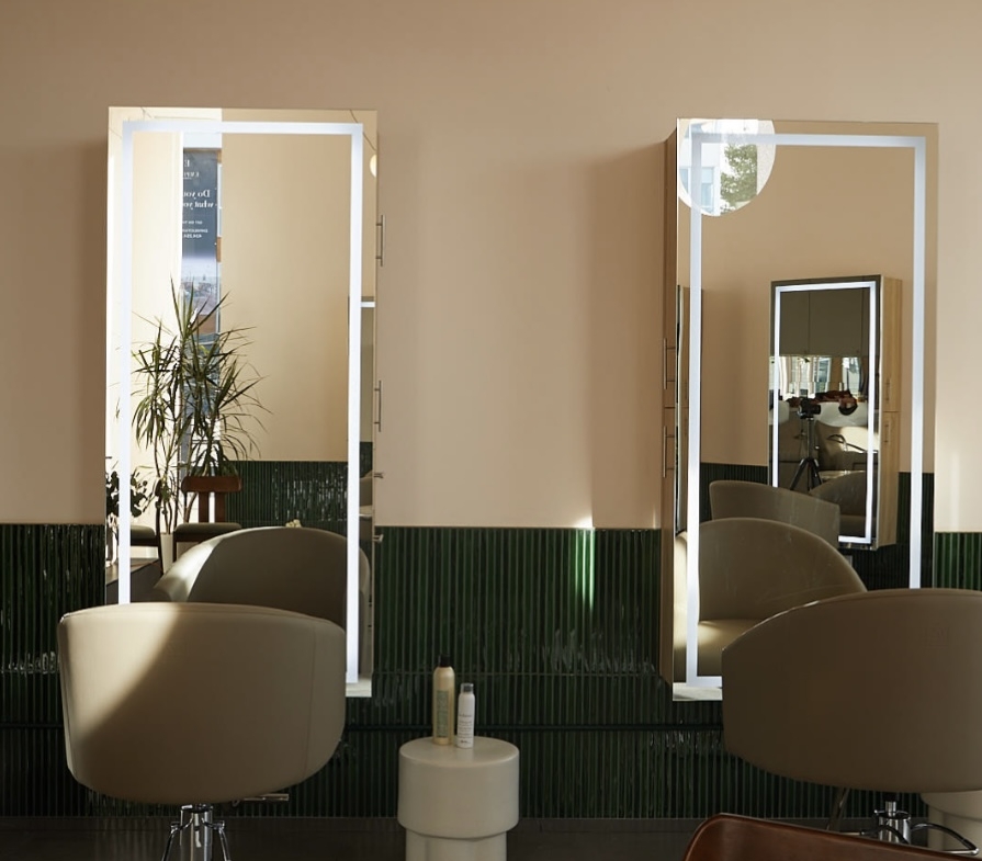 Bright salon interior featuring mirrors, chairs, and stylish decor for hair styling.