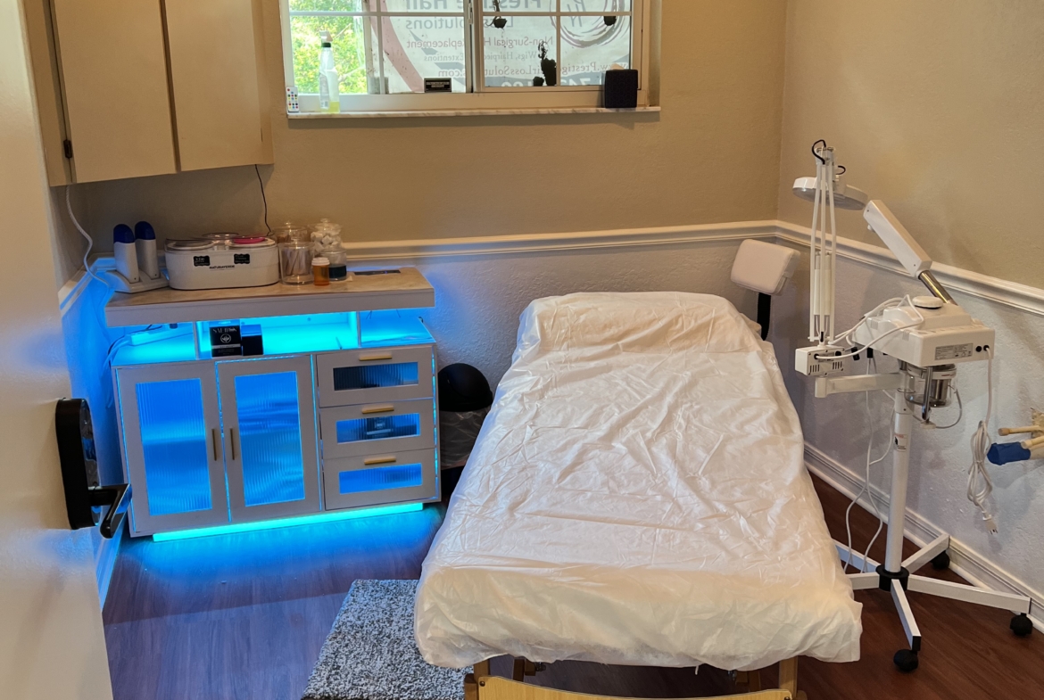 Comfortable beauty treatment room with massage bed and advanced skincare equipment.