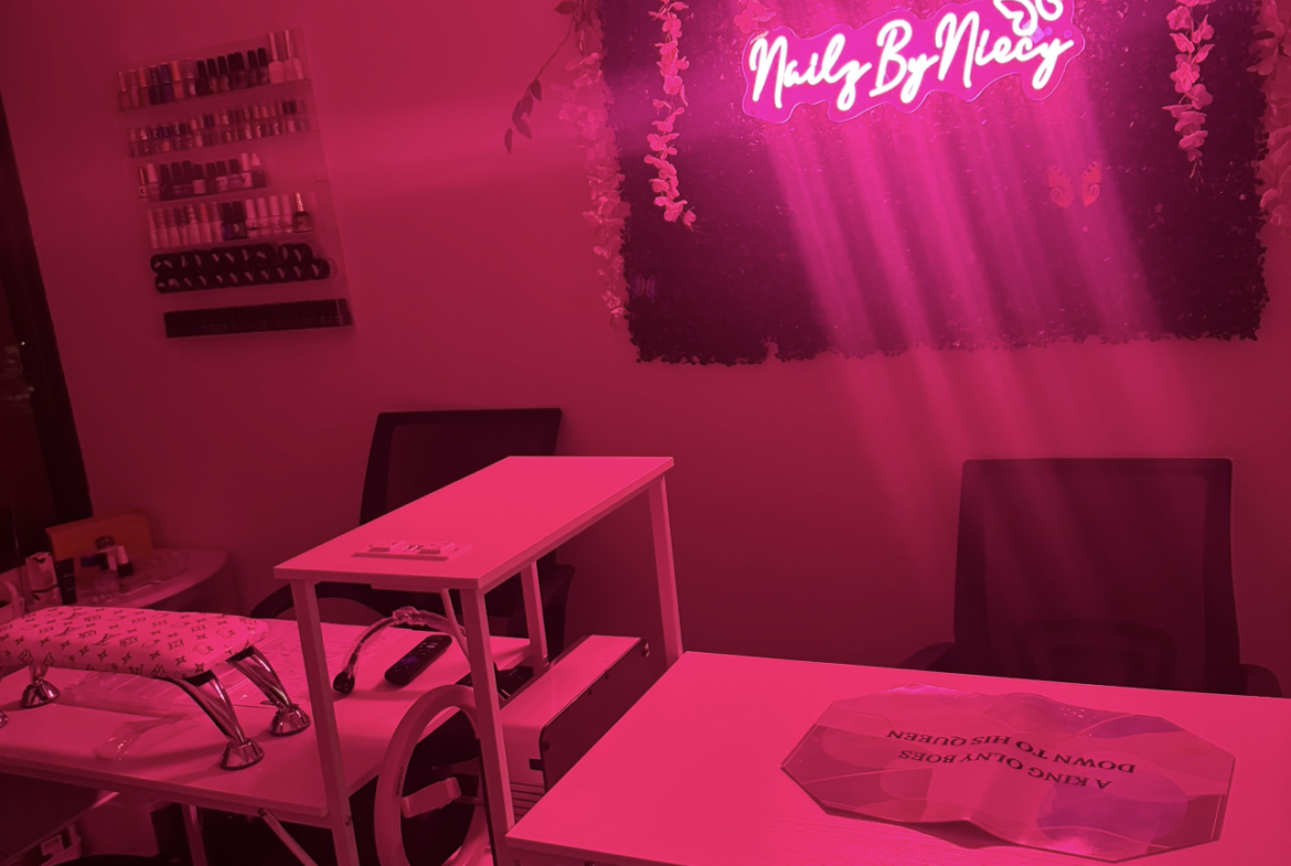 Stylish nail salon with pink neon signs and floral decor. Perfect for nail art and beauty services.