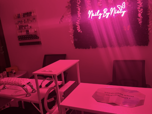 Stylish nail salon with pink neon signs and floral decor. Perfect for nail art and beauty services.