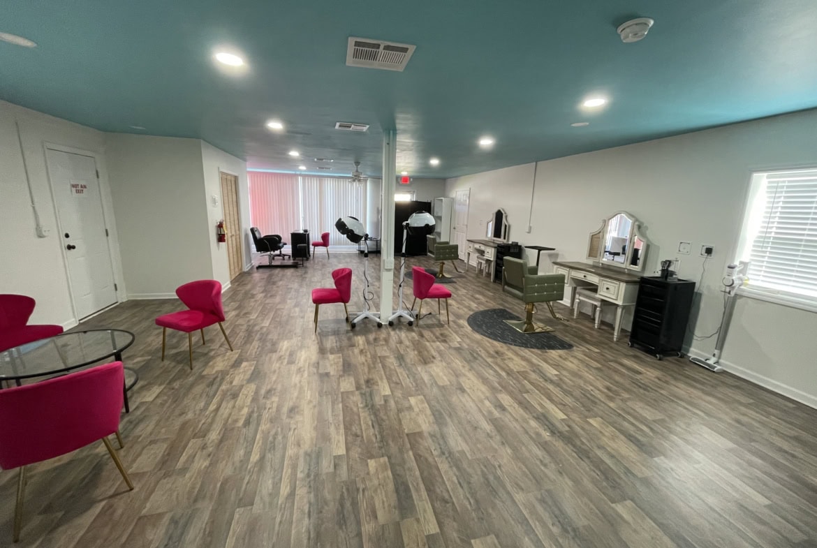 Bright salon interior with styling stations, pink chairs, and hair dryers, perfect for salon renting.
