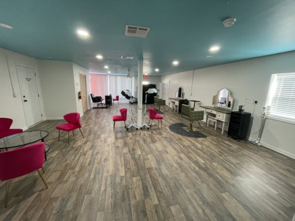Bright salon interior with styling stations, pink chairs, and hair dryers, perfect for salon renting.