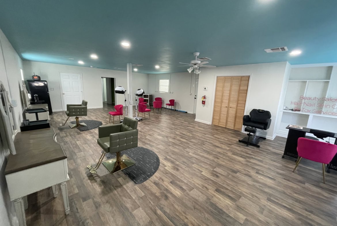 Spacious salon interior with modern hair styling chairs, beauty treatment areas, and comfortable seating.