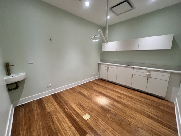 Bright salon room with white cabinetry and wooden floors, ideal for rent by beauty professionals.