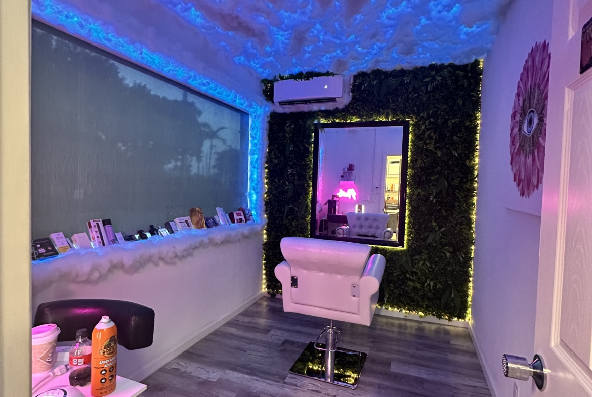 Stylish salon interior featuring cloud ceiling with blue LED lights, plush chair, and decorative wall for a relaxing beauty environment.