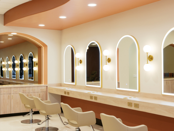 Elegant salon station with comfortable styling chairs and bright LED-lit mirrors for haircuts.