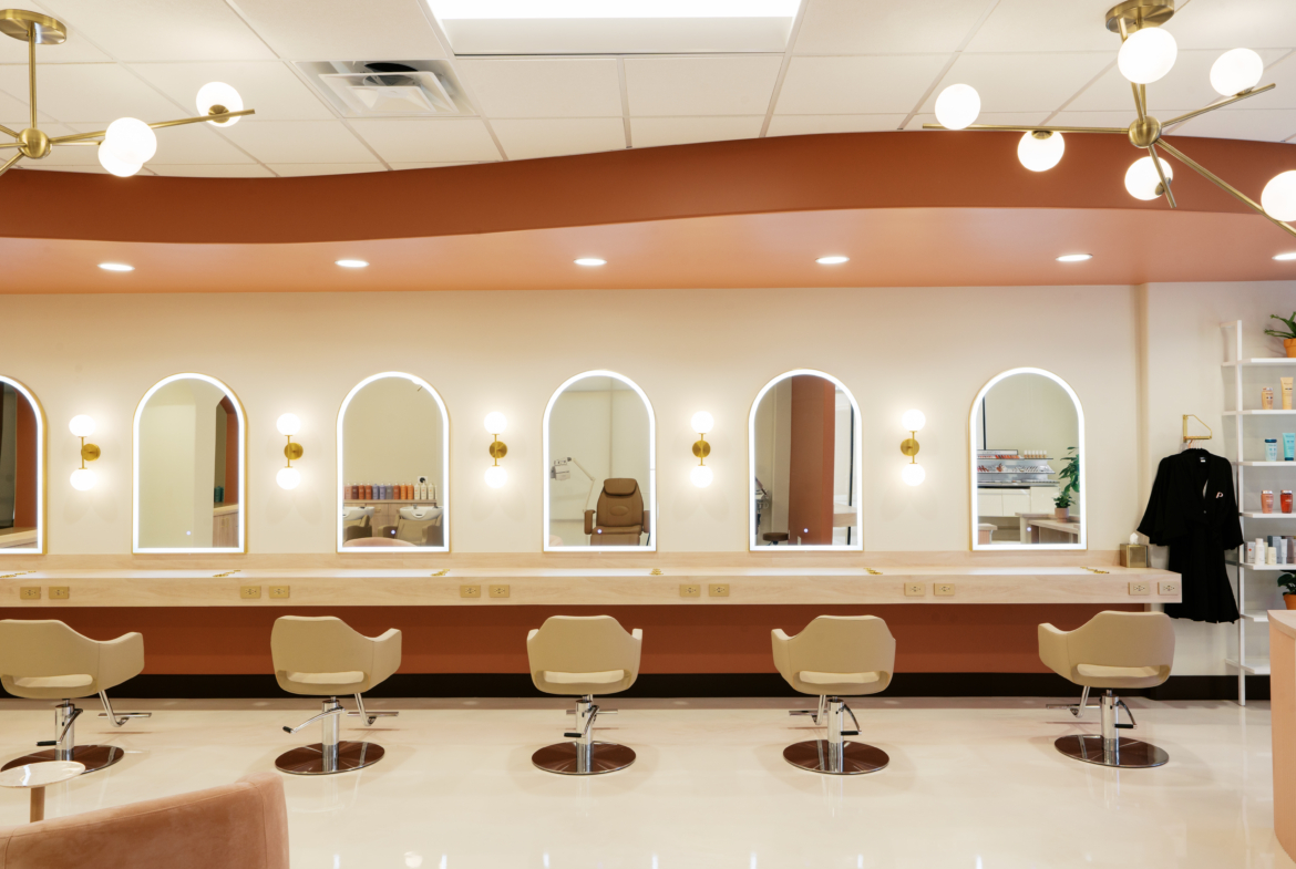 Stylish salon interior featuring mirrors, lighting, and salon chairs for hair services.