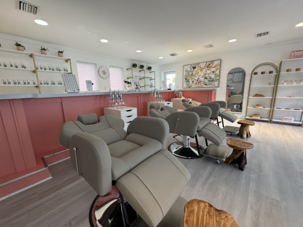 Bright salon with comfortable styling chairs, beauty product displays, and a welcoming atmosphere for clients.