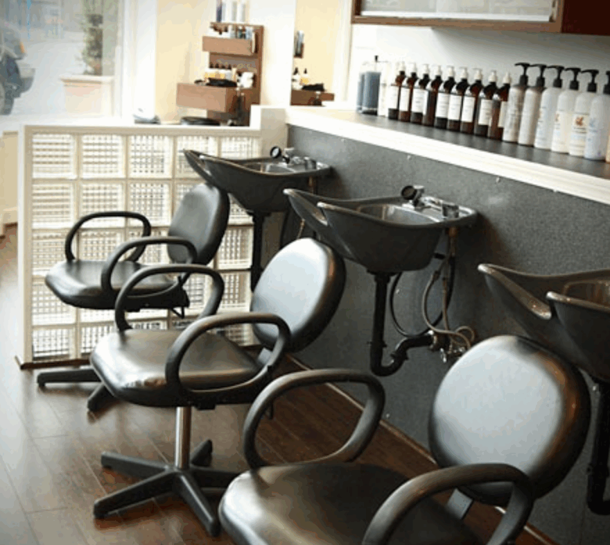 Image of modern hair salon with black washbasins and styling chairs for rent. Ideal for salon owners looking for professional salon rental solutions.