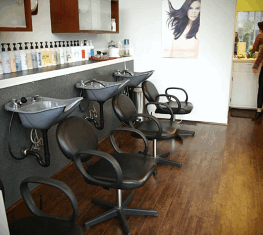 Salon wash stations with chairs and sinks for hair wash services in a modern salon environment.