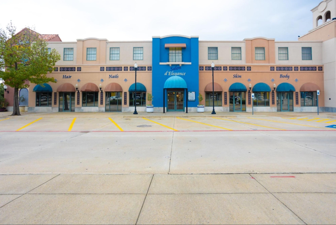 Modern beauty salon building with colorful signage, large windows, and parking lot.