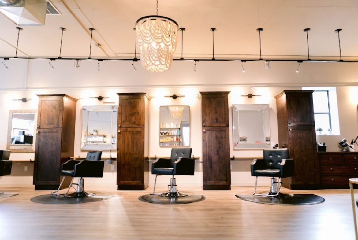 Modern salon with stylish chairs, mirrors, and organized workspace for hair and beauty services.