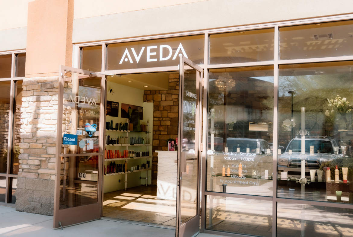 Modern salon front featuring Aveda products and entry door with salon signage.
