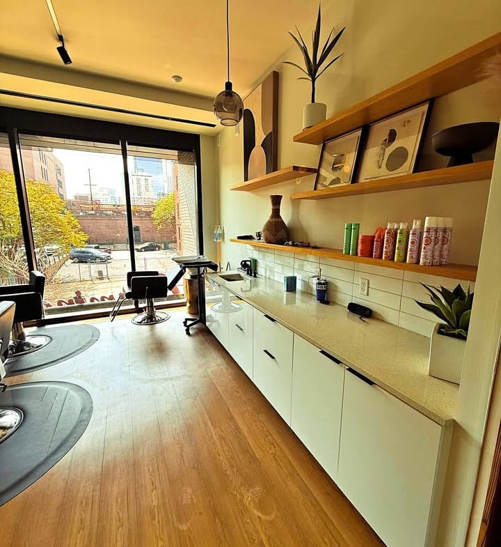 Bright modern salon interior with natural light, stylish decor, and hair styling stations.