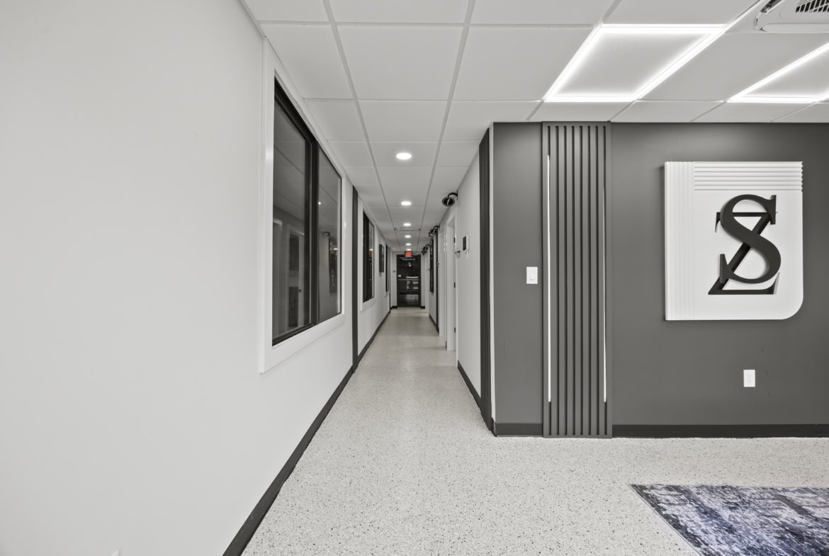 Modern salon interior hallway with sleek design and salon logo on the wall for salon rental services.