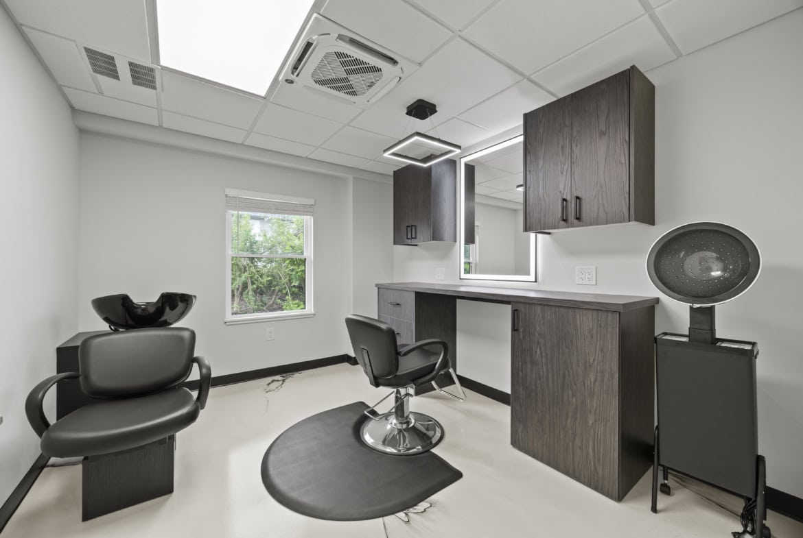 Modern salon space with hair styling chairs, mirror, and hair wash station for rent.