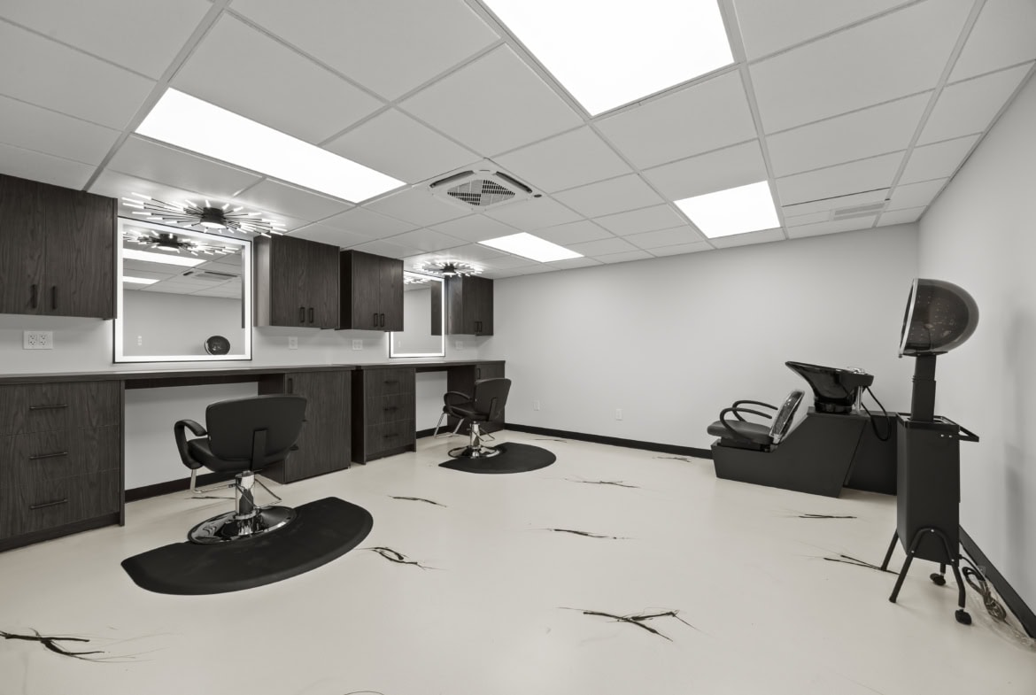 Modern salon hair styling stations with mirrors and chairs for rent or rent-free.