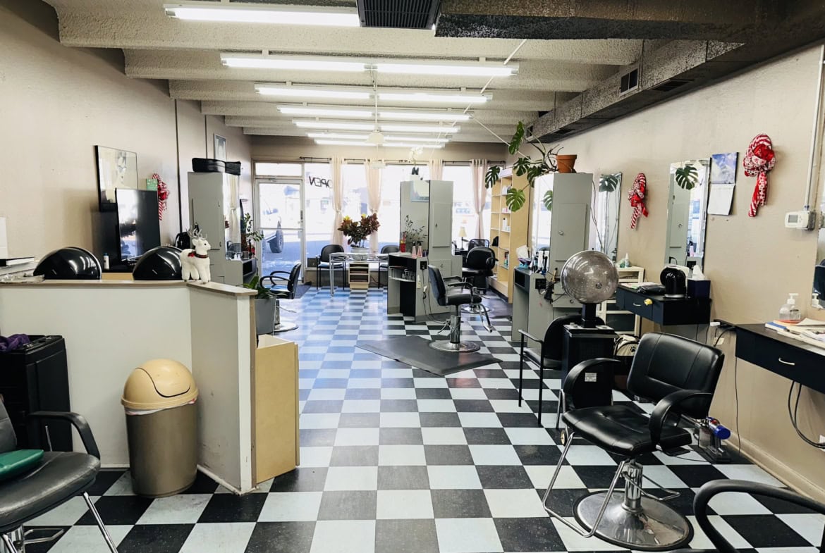 Clean salon styling area with chairs, mirrors, and hairdressing tools for beauty and hair services.