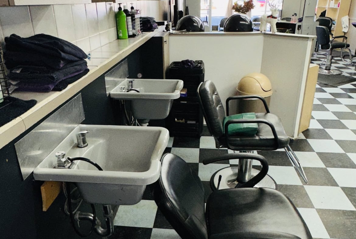 Clean salon station with washing sinks and chairs ideal for hairstyling and beauty services.