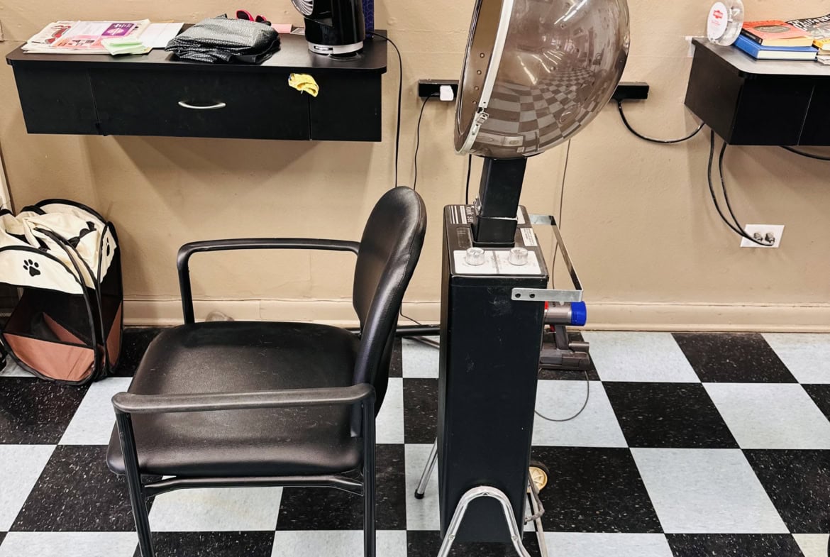 Stylish salon workspace with hood dryer, chair, and essentials for professional hair styling.