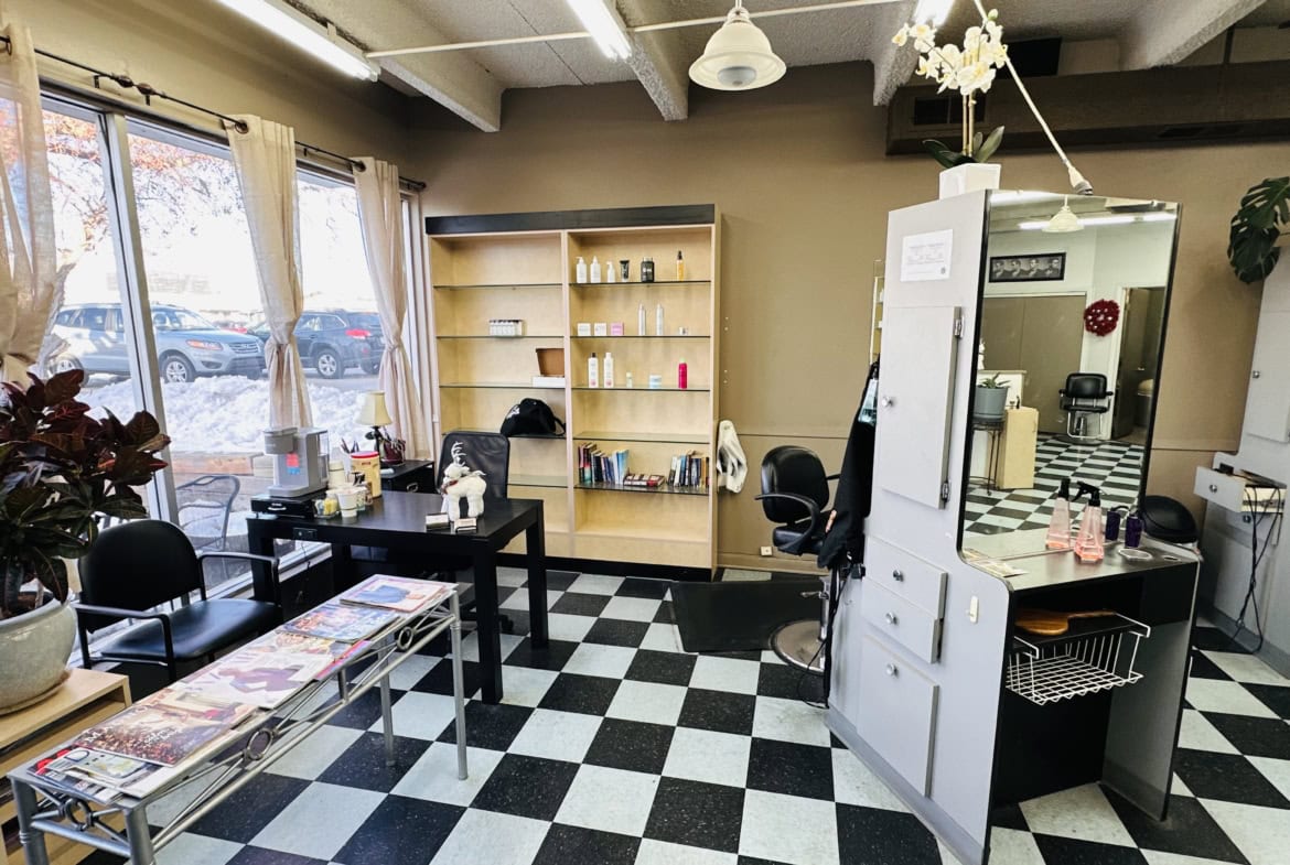 Bright salon space with hair styling stations, shelves, and a welcoming atmosphere for clients.