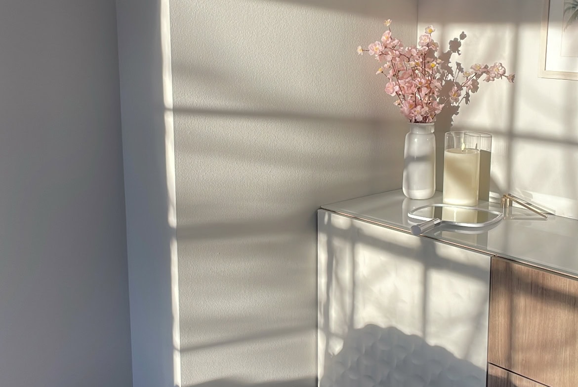 Elegant salon decor featuring a pink flower arrangement and natural sunlight.