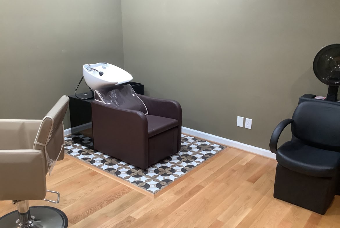 Comfortable salon shampoo station with hair washing sink and salon chairs, ideal for haircare services.