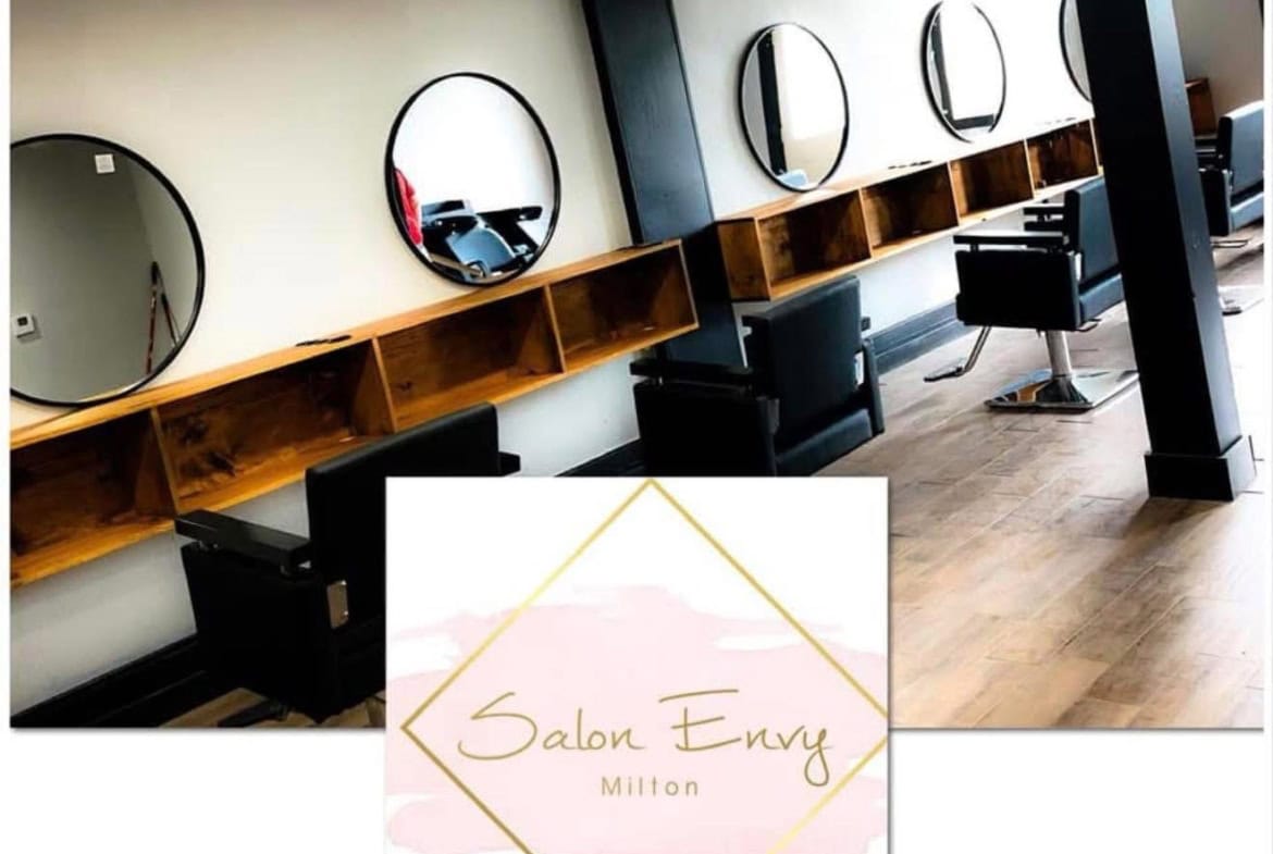 Stylish salon chairs with mirrors in modern salon rental space, showcasing professional hair station setup.