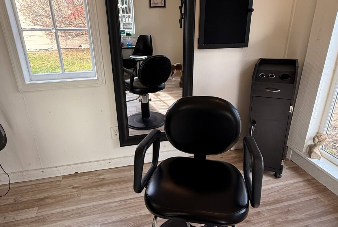 Stylish salon chair with a large mirror and cozy interior decor in a hair salon or beauty studio setting.