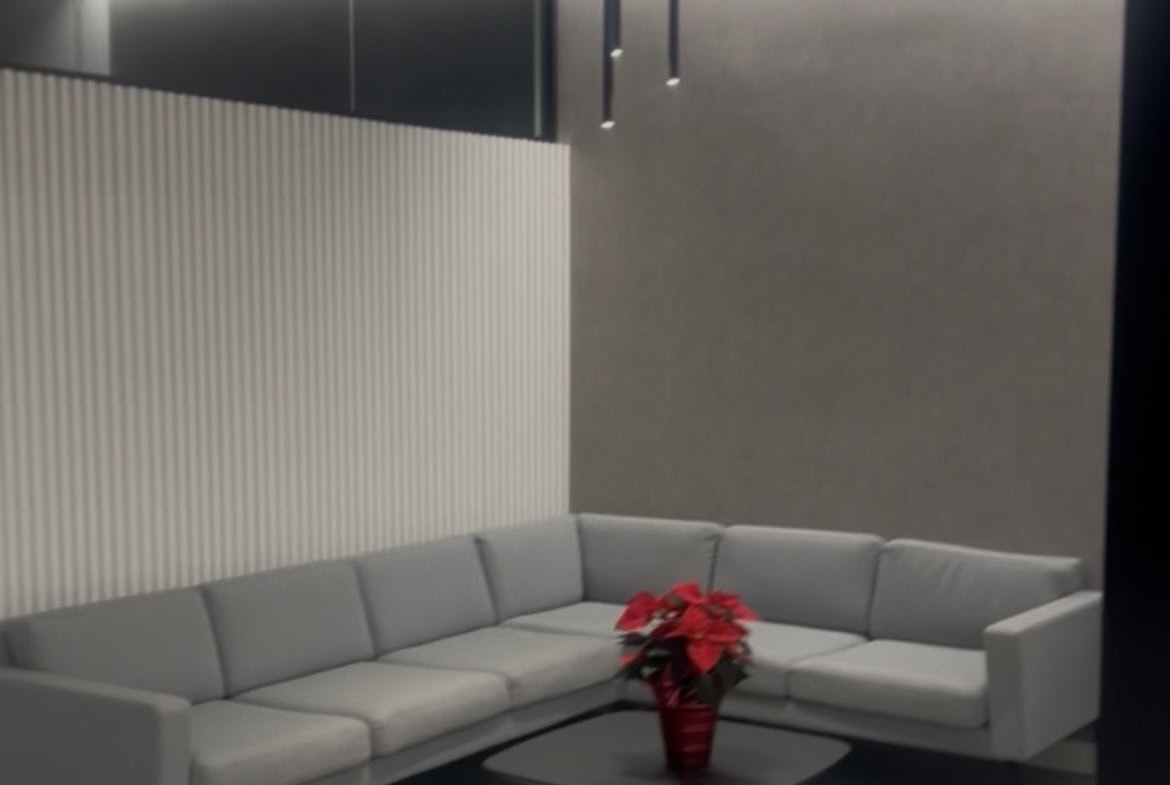 Modern reception lounge with elegant gray sectional sofa and festive red poinsettia plant.