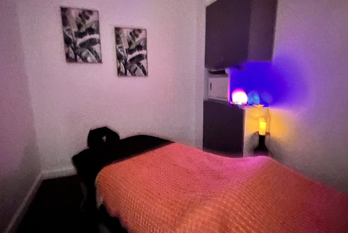Soft lighting and cozy ambiance in a modern massage room with colorful LED lights.