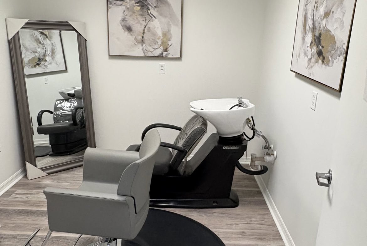 Elegant salon shampoo station with modern decor and comfortable styling chair.